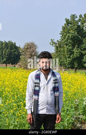 Junger indischer Bauer auf schwarzem Senffeld Stockfoto