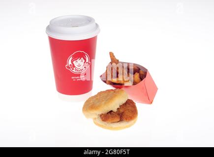 Wendy's Frühstück mit Honig-Hähnchen-Biskuit-Sandwich, gewürzten Kartoffeln und Kaffeetasse Stockfoto