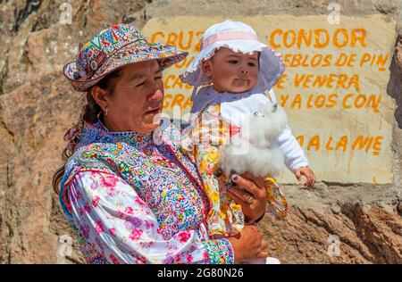 Ältere Frau aus dem Collagua mit Enkelkind posiert am Kreuz des Condors, Colca Canyon, Arequipa, Peru. Stockfoto