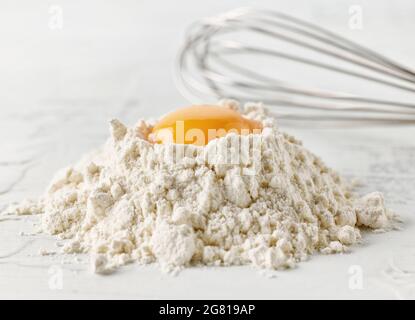 Mehl und Eigelb auf weißem Küchentisch Stockfoto