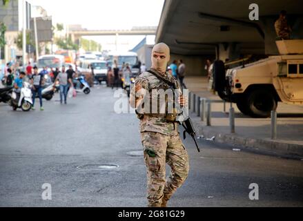 Beirut, Libanon. Juli 2021. Ein Mitglied der libanesischen Armee ist am 16. Juli 2021 in der Nähe der Stelle zu sehen, an der Demonstranten eine Straße in Beirut, Libanon, blockieren. Libanesische Demonstranten haben am Freitag, einen Tag nach dem Rücktritt des designierten Premierministers Saad Hariri, in Beirut zum zweiten Tag die Straßen gesperrt. Hariri kündigte am Donnerstag an, dass er es versäumt habe, ein Kabinett zu bilden, und zitierte dabei unversöhnliche Meinungsverschiedenheiten mit Präsident Michel Aoun. Die Ankündigung hat ein Dutzend Proteste im ganzen Land ausgelöst. Quelle: Bilal Jawich/Xinhua/Alamy Live News Stockfoto