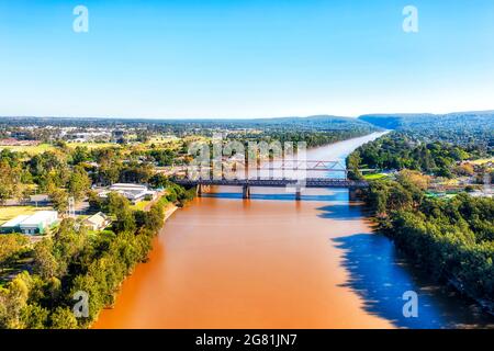 Gelbes, schlammiges Wasser des Nepean River in Penrith, der Stadt Greater Sydney - landschaftlich reizvoller Blick aus der Luft. Stockfoto