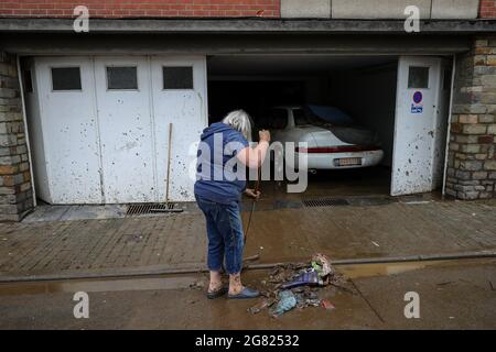 Verviers, Belgien. Juli 2021. Eine Frau reinigt ihre Garage nach dem Hochwasser in Verviers, Belgien, 16. Juli 2021. Belgien hat den 20. Juli zum nationalen Trauertag für die Opfer des Unwetters der letzten Tage erklärt. 21 Menschen starben und 18 wurden am Freitag nach Sturzfluten, bei denen Flüsse an ihren Ufern im Süden und Osten des Landes platzten, als vermisst gemeldet. Quelle: Zhang Cheng/Xinhua/Alamy Live News Stockfoto