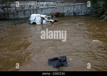 Verviers, Belgien. Juli 2021. Das am 16. Juli 2021 aufgenommene Foto zeigt ein gebrochenes Fahrzeug in einem Fluss in Verviers, Belgien. Belgien hat den 20. Juli zum nationalen Trauertag für die Opfer des Unwetters der letzten Tage erklärt. 21 Menschen starben und 18 wurden am Freitag nach Sturzfluten, bei denen Flüsse an ihren Ufern im Süden und Osten des Landes platzten, als vermisst gemeldet. Quelle: Zhang Cheng/Xinhua/Alamy Live News Stockfoto