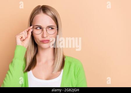 Portrait von attraktiven verdächtige Mädchen berühren Spezifikationen suchen beiseite kopieren Raum Lösung isoliert über beige Pastellfarbe Hintergrund Stockfoto