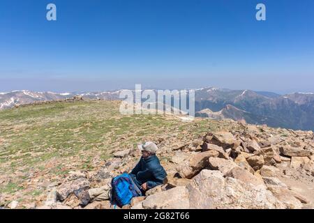 Mann, der auf dem Gipfel des Mount Parnassus in Colorado ruht Stockfoto