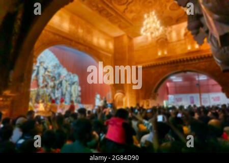 Verschwommenes Bild der Göttin Durga Idol verehrt im dekorierten Durga Puja Pandal, bei farbigem Licht in der Nacht aufgenommen. Es ist das größte Festival von Stockfoto