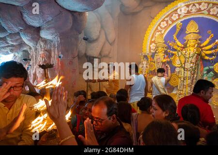 Kolkata, Indien - 17. Oktober 2018 : Hindu-Anhänger, die ihre Hände ausstreuten, um während Sandhi Puja die Wärme der heiligen Lampe zu erreichen und als hinduistische Ritua zu erhalten Stockfoto