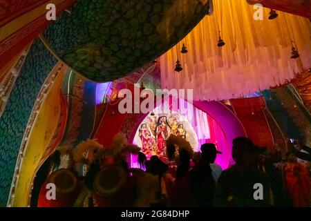 Kolkata, Indien - 17. Oktober 2018 : Dhaakis (Trommler) treten während Durga Puja auf - nachts unter farbigem Licht gedreht. Ein religiöser Brauch von Hinduis Stockfoto