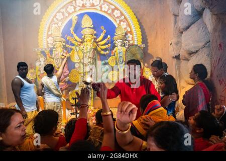 Kolkata, Indien - 17. Oktober 2018 : hinduistische weibliche Anhänger, die ihre Hände ausdehnen, um die Wärme der heiligen Lampe während Sandhi Puja zu erhalten, als hinduistisches Ritual f Stockfoto