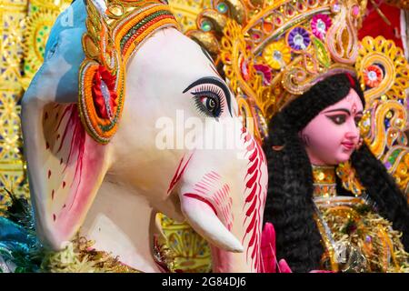 Kolkata, Indien - 17. Oktober 2018 : dekoriertes Idol von herrn Ganesha neben Göttin Durga, Sohn neben Mutter, während Durga Puja angebetet. Große Stockfoto