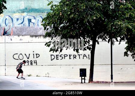 Teenage Boy Skateboarding vor Covid-19 Graffiti, Barcelona, Spanien. Stockfoto