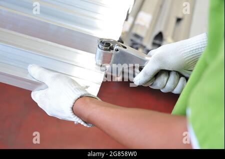 Ein Arbeiter verwendet ein Messwerkzeug mit Stahlarbeiten Stockfoto