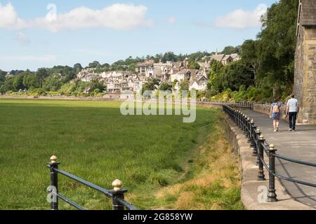 Ein Paar, das an der Promenade in Grange over Sands, Cumbria, England, Großbritannien, spazieren geht Stockfoto