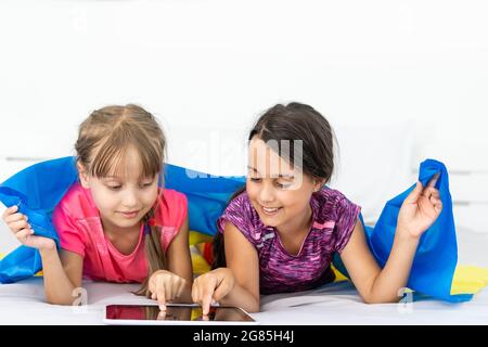 Bildung, Schule, Kunst und Glück Konzept - kleine Kinder mit der Flagge der ukraine Stockfoto