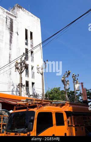 Bangkok / Thailand - November 19 2016: Viele Elektriker-Lineman-Reparaturarbeiter bei Kletterarbeiten am elektrischen Pfosten-Strommast in Bangkok Stockfoto