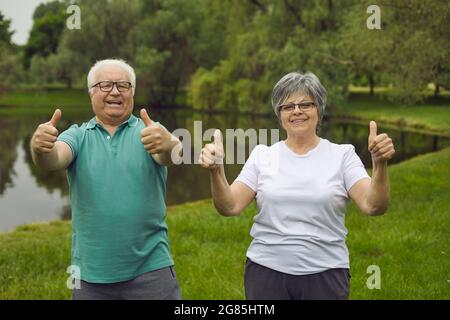 Porträt eines glücklichen älteren Ehepaares, das nach einer Sportübung in der Natur Daumen nach oben gibt Stockfoto