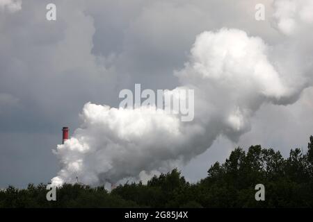 Rauch aus der Fabrik aus Kaminen an einem sonnigen Sommertag, der sehr hoch schwebt Stockfoto