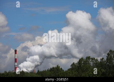 Rauch aus der Fabrik aus Kaminen an einem sonnigen Sommertag, der sehr hoch schwebt Stockfoto