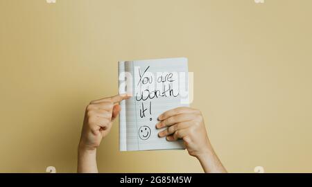 Eine ermutigende NOTIZ, DIE AUF Papier vor gelbem Hintergrund GESCHRIEBEN IST Stockfoto
