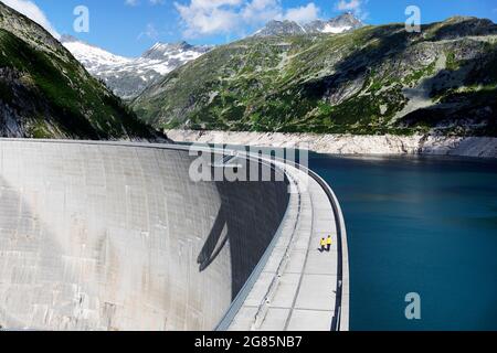 Mutter und Sohn wandern an einem Sommertag auf einem Bergdamm am Stausee Kolnbreinsperre, Maltatal, Kärnten, Österreich Stockfoto