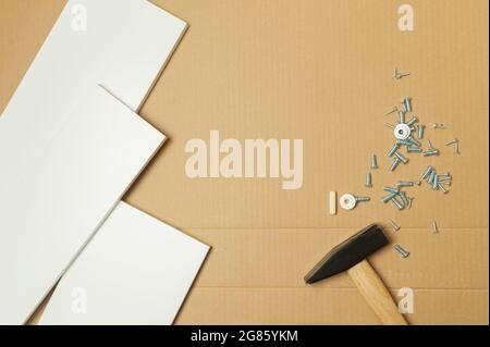 Mechaniker montierte die Möbel im Haus nach dem Handbuch, zusammen mit der mechanischen Ausrüstung. Durch Hammerschlämmen der Nägel Messen mit einem Klebeband Stockfoto