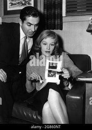 TYRONE POWER und HILDEGARD KNEF am Set sind offen und überprüfen die Kontaktabzüge von Werbestills während der Dreharbeiten des DIPLOMATISCHEN KURIERERS 1952 Regisseur HENRY HATHAWAY aus dem Roman finster errand von Peter Cheyney Twentieth Century Fox Stockfoto