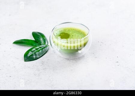 Grüner Matcha-Tee-Drink auf hellem Stein Hintergrund. Konzept der japanischen Teezeremonie. Speicherplatz kopieren Stockfoto