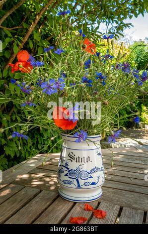 Nostalgisches Feldbukett mit Maismohn (Papaver rhoeas) und Kornblumen (Centaurea cyanus) in einer alten Vase, Bayern, Deutschland, Europa Stockfoto