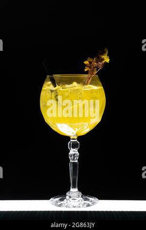 Luxuriöser Gin hass Orangencocktail mit Eis im Glas auf schwarzem Hintergrund Stockfoto