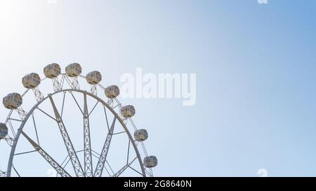 Panoramablick auf ein großes Riesenrad über den blauen Himmel im Vergnügungspark. Festivalkonzept Stockfoto