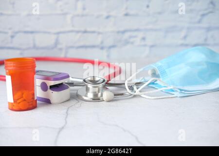 Nahaufnahme von blauen OP-Masken, Stethoskop und Pillenbehälter o ntable Stockfoto