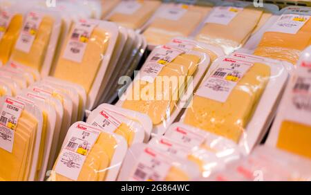 POZNAN, POL - APR 28, 2021: Käse wird in der Milchabteilung eines Supermarkts zum Verkauf angeboten Stockfoto