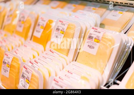 POZNAN, POL - APR 28, 2021: Käse wird in der Milchabteilung eines Supermarkts zum Verkauf angeboten Stockfoto