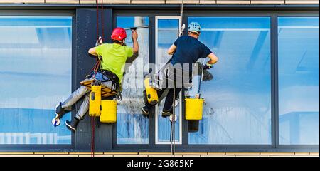 Zwei Männer putzten Fenster in einem Bürogebäude Stockfoto