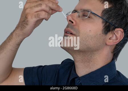 Der Mann nach Hause führt einen schnellen Coronavirus-Nasenabstrich auf sich selbst durch. Konzept der Kontrolle und Prävention von covid-19 Stockfoto