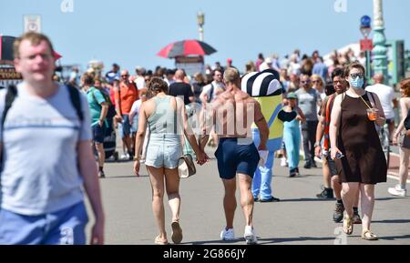 Brighton UK 17. Juli 2021 - Besucher genießen heute an der Strandpromenade von Brighton ein warmes, sonniges Wetter. Für das Wochenende wird eine Hitzewelle in ganz Großbritannien prognostiziert, wobei die Temperaturen in einigen Gebieten voraussichtlich über 30 Grad Celsius erreichen werden : Credit Simon Dack / Alamy Live News Stockfoto