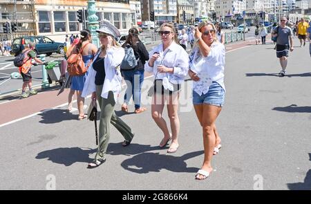 Brighton UK 17. Juli 2021 - Besucher genießen heute an der Strandpromenade von Brighton ein warmes, sonniges Wetter. Für das Wochenende wird eine Hitzewelle in ganz Großbritannien prognostiziert, wobei die Temperaturen in einigen Gebieten voraussichtlich über 30 Grad Celsius erreichen werden : Credit Simon Dack / Alamy Live News Stockfoto