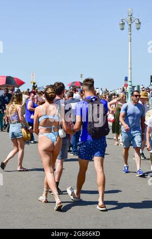 Brighton UK 17. Juli 2021 - Besucher genießen heute an der Strandpromenade von Brighton ein warmes, sonniges Wetter. Für das Wochenende wird eine Hitzewelle in ganz Großbritannien prognostiziert, wobei die Temperaturen in einigen Gebieten voraussichtlich über 30 Grad Celsius erreichen werden : Credit Simon Dack / Alamy Live News Stockfoto