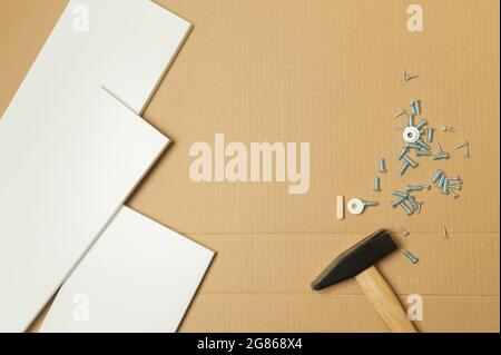 Mechaniker montierte die Möbel im Haus nach dem Handbuch, zusammen mit der mechanischen Ausrüstung. Durch Hammerschlämmen der Nägel Messen mit einem Klebeband Stockfoto