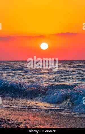 Regenbogenfarben des schönsten Sonnenuntergangs am Strand von Ialysos auf der griechischen Insel Rhodos. Stockfoto