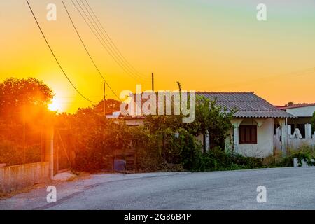 Goldene Farben des schönsten Sonnenuntergangs am Strand von Ialysos auf der griechischen Insel Rhodos. Stockfoto