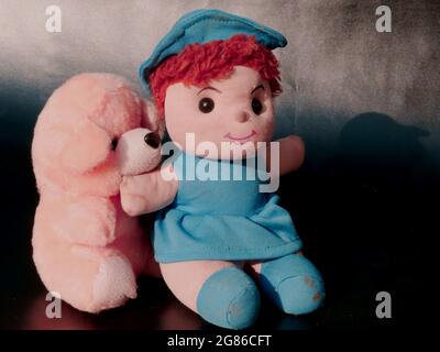 Baumwolle weiche Spielzeug Puppe stehen mit Hund Hund Spielzeug auf grauem Hintergrund, Kinder spielen Objekt Bild Stockfoto