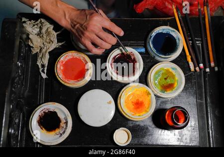 (210717) -- JINGDEZHEN, 17. Juli 2021 (Xinhua) -- Cheng Xiaoqian mischt Pigment in einem Studio in Jingdezhen, ostchinesische Provinz Jiangxi, 14. Juli 2021. Guyacai, wörtlich übersetzt malerische Farbdekoration auf Chinesisch, ist eine Art Porzellandekoration, die in den 1980er Jahren erfunden wurde. Seine Spezialität liegt in einer Kombination aus chinesischer Kunst und westlichen Gemälden. Ein Guyacai-Maler muss nicht nur über Pigmentmerkmale gut Bescheid wissen, sondern auch die Fähigkeiten der westlichen und traditionellen chinesischen Malerei, Kalligraphie und Siegel beherrschen, um die Schönheit der klassischen und malerischen Kunst zum Ausdruck zu bringen Stockfoto