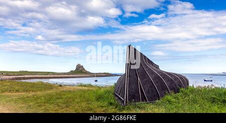 Umgedrehte Fischerboote werden als Lagerhütten oder Schuppen auf der Heiligen Insel Lindisfarne an der Küste von Northumberland eingesetzt. Stockfoto