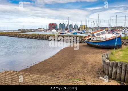 Ein altes Boot, das in der Nähe von Amble Marina, Amble, Northumberland, England, Großbritannien, vertäut ist Stockfoto