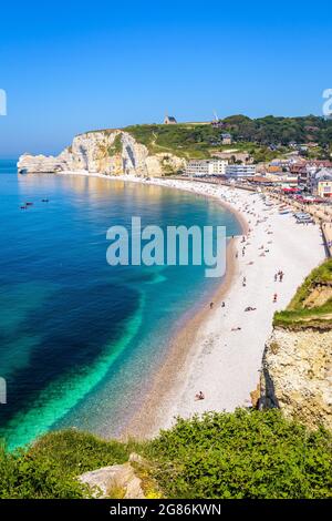 Der Strand von Etretat in der Normandie, eine beliebte Küstenstadt, die für ihre Kreidefelsen bekannt ist, mit der Kapelle Notre-Dame de la Garde mit Blick auf die Klippe von Amont. Stockfoto