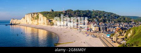 Der Strand von Etretat in der Normandie, eine beliebte Küstenstadt, die für ihre Kreidefelsen bekannt ist, mit der Kapelle Notre-Dame de la Garde mit Blick auf die Klippe von Amont. Stockfoto