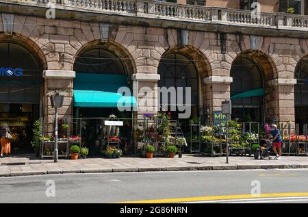 Außenansicht des Orientalischen Marktes in der Via XX Settembre, einer der Hauptstraßen von Genua, mit den Pflanzen eines Blumenladens auf dem Bürgersteig, Italien Stockfoto