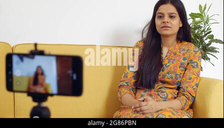 Hübsche indische Frau zeichnet ein Video auf Stockfoto